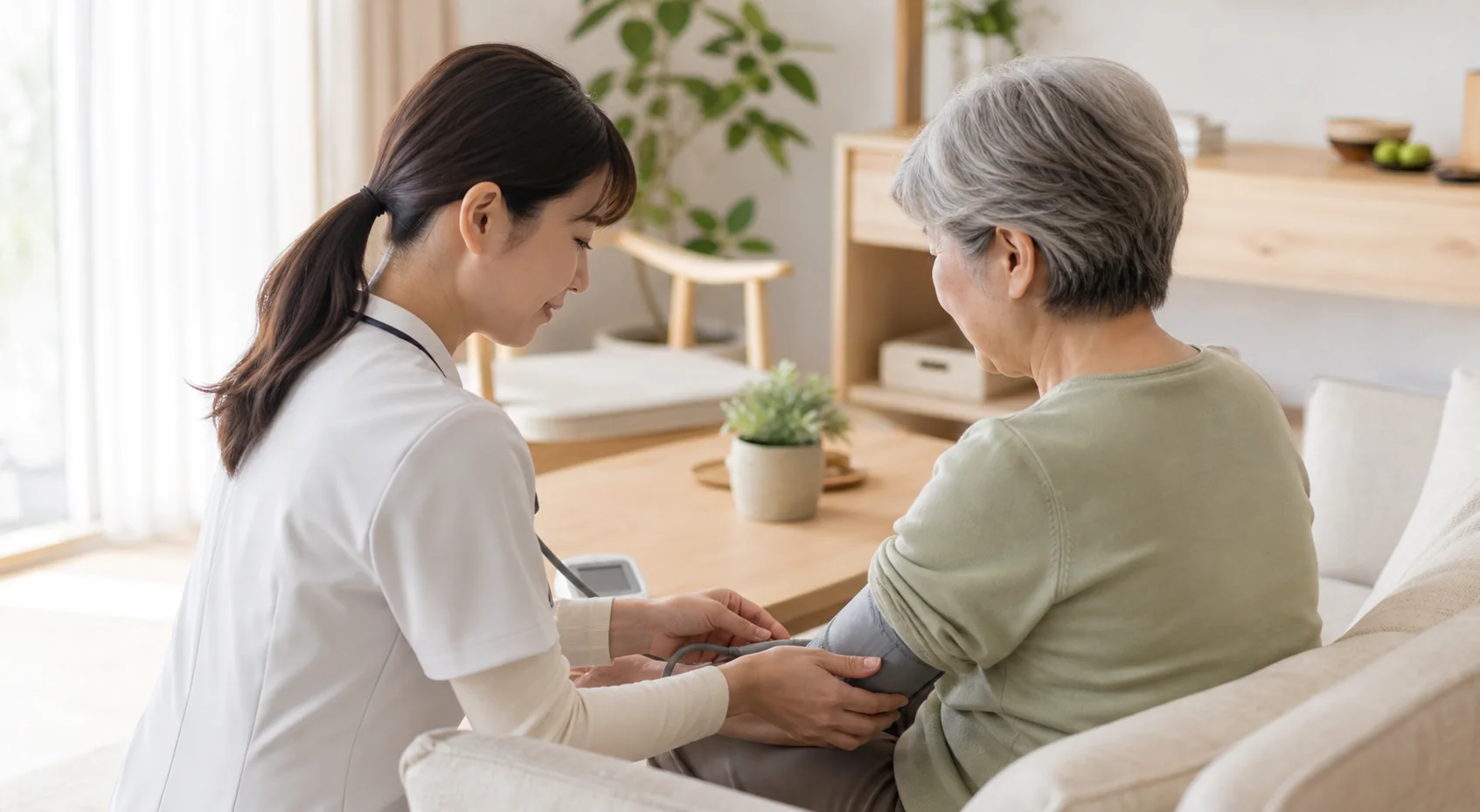 ご自宅で利用者さまの血圧を確認する訪問看護師